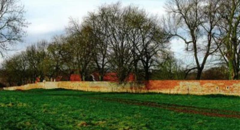 Restored garden wall from the south-east - the visible holes were cut to give the defenders a better field of fire (Martin Drury)