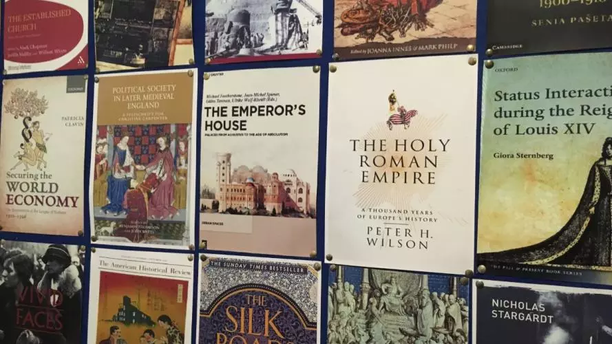 Historical book covers on display on a wall