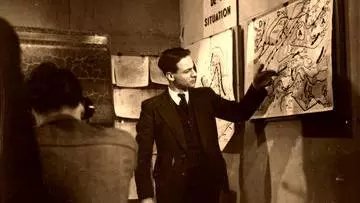 A man pointing at a weather map on the wall