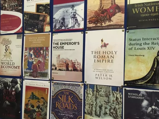Historical book covers on display on a wall