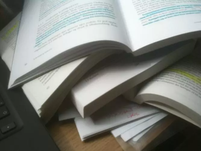 A pile of open text books with sentences highlighted