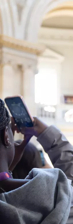 A school pupil taking a picture of a library ceiling with her phone